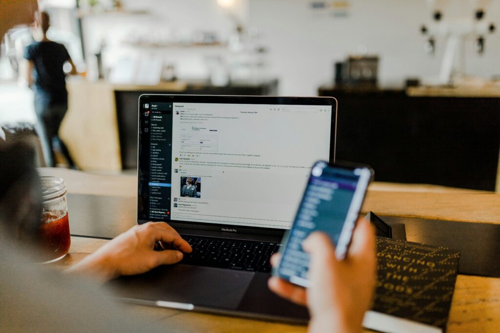 person using phone and laptop person using phone and laptop